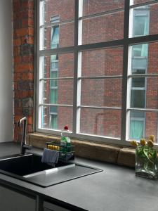 a kitchen counter with a sink and a window at Industrial Escape -Kelham Island in Sheffield