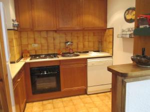 eine Küche mit Holzschränken, einem Herd und einer Spüle in der Unterkunft Appartement au Pla de l'Ermita dans la Vallée de BoÏ , Pyrénées Catalanes in Pla de l'Ermita + 5 Fotos