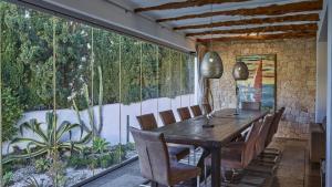 a dining room with a wooden table and chairs at Santa Eulalia - 4739 Ibiza in Cala Llonga