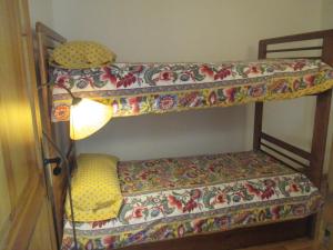 zwei Etagenbetten in einem Zimmer mit einer Lampe in der Unterkunft Appartement au Pla de l'Ermita dans la Vallée de BoÏ , Pyrénées Catalanes in Pla de l'Ermita