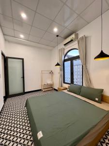 a bedroom with a large green bed and a window at Homestay Beach View 2 in Phú Hiệp