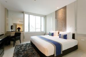 a hotel room with a bed and a desk and a desk at Mandarin Hotel Managed by Centre Point in Bangkok
