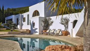 a house with a swimming pool in front of a house at Santa Eulalia - 4739 Ibiza in Cala Llonga