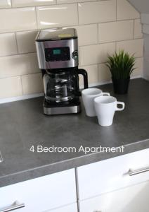 eine Kaffeemaschine auf einer Küchentheke mit zwei Tassen in der Unterkunft Cozy Apartment in Bedburg-Hau in Hau