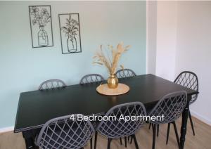 una mesa de comedor negra con sillas y un jarrón. en Cozy Apartment in Bedburg-Hau, en Hau