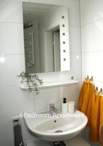 y baño con lavabo blanco y espejo. en Cozy Apartment in Bedburg-Hau, en Hau