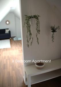 una habitación con una pared blanca con plantas. en Cozy Apartment in Bedburg-Hau en Bedburg Hau