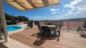 une terrasse avec une table, des chaises et une piscine dans l'établissement Perle, à Nice