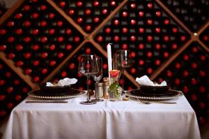 uma mesa com copos de vinho e pratos em Coach House Hotel & SPA Tzaneen em Tzaneen