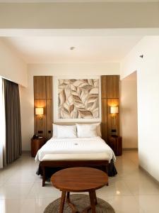 a hotel room with a bed and a table at Crystalkuta Hotel - Bali in Kuta