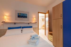 a bedroom with a large white bed with blue pillows at Casa Bellaria by RivedelSalento vista mare Castro in Castro di Lecce