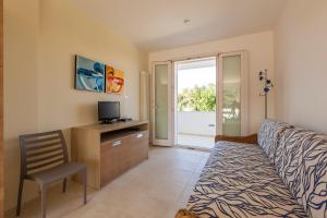 a bedroom with a bed and a desk with a television at Casa Bellaria by RivedelSalento vista mare Castro in Castro di Lecce