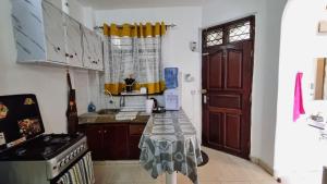 a kitchen with a table in the middle of a room at Gee's Hidden Gem Apartment in Mombasa CBD - Parking in Mombasa