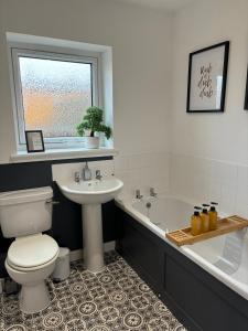 a bathroom with a toilet and a sink and a tub at Gateway Apartment in Inverness