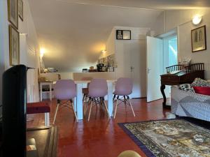 a living room with a table and purple chairs at plein coeur de BANON in Banon