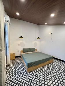 een slaapkamer met een bed en een witte muur bij Homestay Beach View 2 in Phú Hiệp