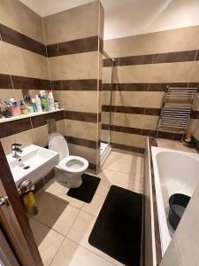 een badkamer met een wastafel, een toilet en een bad bij Kendras home in Manchester
