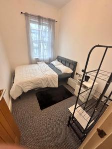een kleine slaapkamer met een bed en een raam bij Kendras home in Manchester