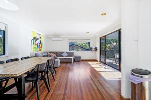 a dining room and living room with a table and chairs at Ammaboolah at Hat Head - 36 Hutcheson Street in Hat Head