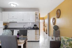 a kitchen and living room with white cabinets and a table at Paraíso Playa in Puerto Naos +13 photos