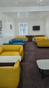 a waiting room with yellow and blue couches and a tv at Hotel Blackpool in Blackpool