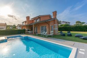 een villa met een zwembad voor een huis bij Isola di Albarella in Isola Albarella