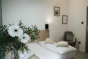 カルパチにあるWilla Skałkaの白いシーツと花が飾られたベッド2台が備わる客室です。