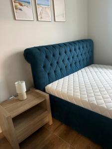- un lit en touffet bleu dans une chambre avec une table dans l'établissement PORTA MARE KOŁOBRZEG Ul GEN MACZKA 29 3, à Kołobrzeg