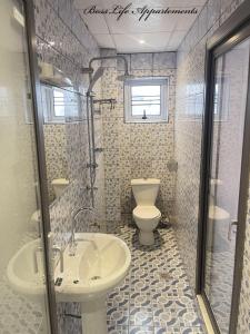 y baño con lavabo y aseo. en BOSSLIFE APARTMENTS-TERMINUS SAINT MICHEL DERRIERE Barcelone Hôtel, en Douala