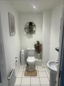 a white bathroom with a toilet and a sink at Luxury Furnished 2 Bed Northampton apartment with Balcony near NN5 stadium in Upton
