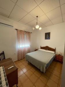 een slaapkamer met een bed, een dressoir en een tafel bij Finca La Tacita - Jazmín in Conil de la Frontera