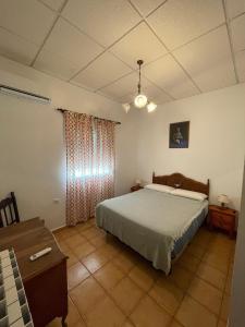 Un dormitorio con una cama, una cómoda y una mesa. en Finca La Tacita - Jazmín, en Conil de la Frontera