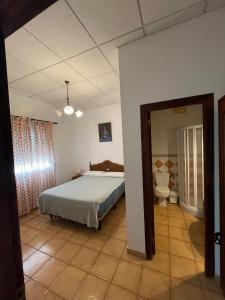 een slaapkamer met een bed en een toilet. bij Finca La Tacita - Jazmín in Conil de la Frontera