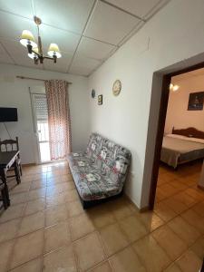 una sala de estar con un sofá y una cama en Finca La Tacita - Jazmín, en Conil de la Frontera