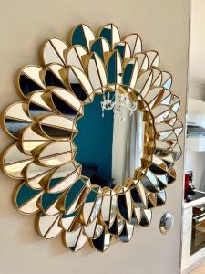 a gold and blue mirror on a wall at Appartement de charme avec balcon au pied des commerces in Béziers