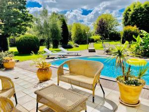 un patio con sillas y una piscina en Villa de charme au milieu des vignes, en Saint-Aubin-de-Blaye