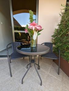 un jarrón de flores sentado en una mesa con sillas en Oslo Gardens Bed & Breakfast, en Entebbe