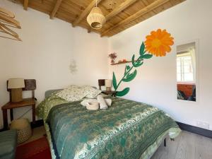 ein Schlafzimmer mit einem Bett mit einer Blume an der Wand in der Unterkunft Casa SanAndo Integrative Medicine Treat & ReTreat Center in Covas