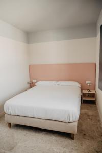 1 dormitorio con 1 cama blanca y 2 mesitas de noche en Azul y Limón, en Córdoba