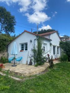 ein weißes Haus mit einem Tisch und einem Regenschirm in der Unterkunft Casa SanAndo Integrative Medicine Treat & ReTreat Center in Covas