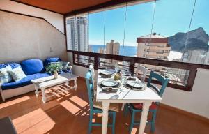 Habitación con mesa, sillas y sofá en Edificio Coral Beach en Calpe