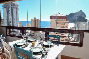 comedor con mesa, sillas y ventana en Edificio Coral Beach en Calpe