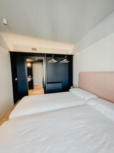 Un dormitorio con dos camas blancas y una pared azul. en Azul & Limón Apartments, en Córdoba 40 fotos más