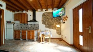 een keuken met een tafel en een tv aan de muur bij MeA on the Lake Cavalcaselle in Cavalcaselle