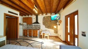 een kamer met een keuken en een tv aan de muur bij MeA on the Lake Cavalcaselle in Cavalcaselle