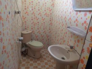 a small bathroom with a toilet and a sink at Kunam Beach Rest Inn in Batticaloa