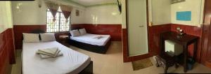 um pequeno quarto com 2 camas e um espelho em Ditar Guest House S em Battambang