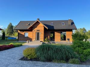 a wooden house with a driveway in front of it at Grand Rozbój House Beskid Niski, Spa Ogrodowe 