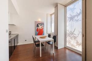 una cucina e una sala da pranzo con tavolo e sedie bianchi di Fine Arts Studios by Olala Homes a Porto