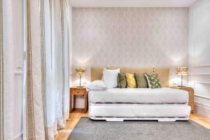 een slaapkamer met een wit bed met 2 lampen en een tapijt bij Apartamento Canalejas Place en Madrid in Madrid